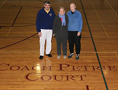 Coach Ed Petrie, the state’s winningest public high school boys basketball coach, his wife, Nancy, and Joe Vas, left, the East Hampton School District’s athletic director, admired the new “Coach Petrie Court” logo at the high school. Coach Ed Petrie, the state’s winningest public high school boys basketball coach, his wife, Nancy, and Joe Vas, left, the East Hampton School District’s athletic director, admired the new “Coach Petrie Court” logo at the high school.