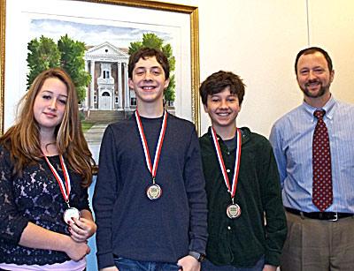 Alexandra Ebel, Jason Karlin, and Jimmy Makrianes, with their East Hampton Middle School social studies teacher, Peter Friscia, displayed the medals they picked up at the Long Island regional celebration of National History Day.
