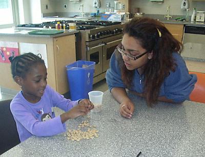 Kathleen Santiago, a high school student, works with Zion Osei, a preschooler, in East Hampton High School’s Food and Fun program, which pairs older students with younger ones.