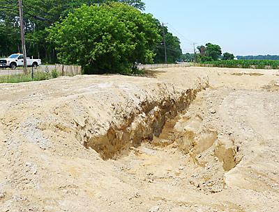 Work on a drainage basin being built by East Hampton Town was halted when Suffolk officials learned the work was being done on farmland over which the county owns development rights.