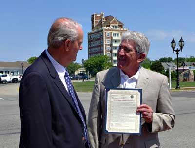 John Keeshan, who successfully lobbied to rename the Plaza after Carl Fisher, received a copy of the East Hampton Town resolution making it official on June 24 from Supervisor Larry Cantwell. John Keeshan, who successfully lobbied to rename the Plaza after Carl Fisher, received a copy of the East Hampton Town resolution making it official on June 24 from Supervisor Larry Cantwell.