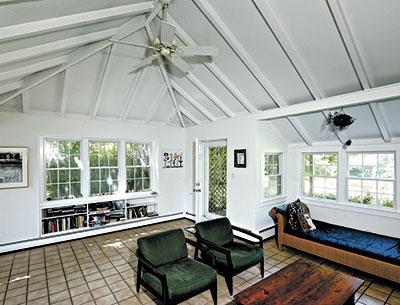 The living room of a model house at Montauk Highway and Gardiner Drive shows the cathedral ceiling, open beams, and built-in bookcases common in these houses.