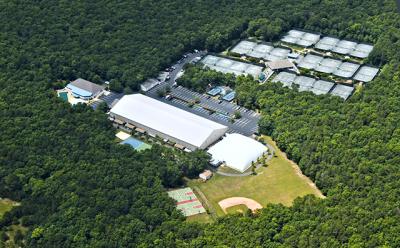 The cleared land to the lower right of the photo, including the present “bubble,” which is to be moved to seasonally cover the four courts to the left of the outdoor clubhouse, is the area under discussion with the East Hampton Town Planning Board. The cleared land to the lower right of the photo, including the present “bubble,” which is to be moved to seasonally cover the four courts to the left of the outdoor clubhouse, is the area under discussion with the East Hampton Town Planning Board.