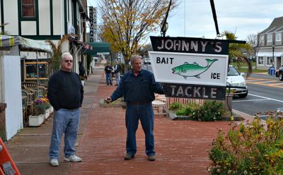 Johnny Kronuch, left, owner of Johnny’s Bait and Tackle, stood with Tom Brown, who has been caring for the store’s neon sign for many years. The business is closing and the sign will go to Mr. Kronuch’s son.