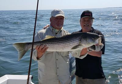 Peter Honerkamp, right, fishing with Capt. Ken Rafferty in Gardiner’s Bay, caught a 30-pound striped bass, his first.
