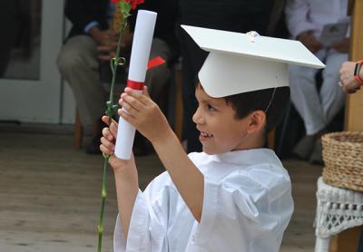 Clad in caps and “gowns,” prekindergartners graduating from the Eleanor Whitmore Early Childhood Center on Friday morning got a diploma and a red carnation. Clad in caps and “gowns,” prekindergartners graduating from the Eleanor Whitmore Early Childhood Center on Friday morning got a diploma and a red carnation.