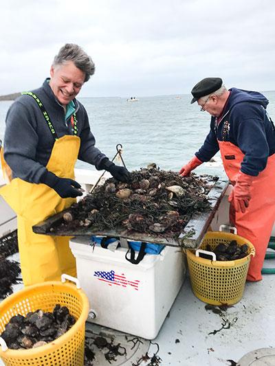 Robert Cugini of Seattle and Ray Sperling of Sag Harbor helped sort through scallops on Monday morning. Robert Cugini of Seattle and Ray Sperling of Sag Harbor helped sort through scallops on Monday morning.