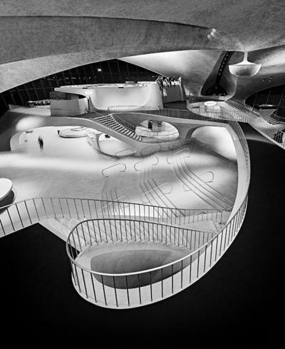 Balthazar Korab's 1964 interior view of the TWA Flight Center at J.F.K. International Airport, emphasizes the complexity of Eero Saarinen's curvilinear architecture. Balthazar Korab's 1964 interior view of the TWA Flight Center at J.F.K. International Airport, emphasizes the complexity of Eero Saarinen's curvilinear architecture.