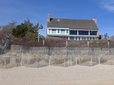 The owners of a beachfront Lily Pond Lane property in a coastal erosion hazard area want to tear down this house and build a new one in its place.