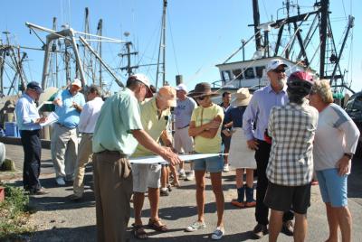 Harry Dodson of the planning firm Dodson and Flinker, at left in the green shirt, held a map of Montauk's dock area while participants in a walking tour there yesterday talked about problem areas and opportunities for improvement. Behind him with the note pad was his partner, Peter Flinker. Harry Dodson of the planning firm Dodson and Flinker, at left in the green shirt, held a map of Montauk's dock area while participants in a walking tour there yesterday talked about problem areas and opportunities for improvement. Behind him with the note pad was his partner, Peter Flinker.