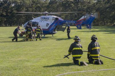 Firefighters stood by with a charged hose line as a precaution while other firefighters and E.M.T.s moved a patient to the Suffolk County medevac helicopter on Saturday. Firefighters stood by with a charged hose line as a precaution while other firefighters and E.M.T.s moved a patient to the Suffolk County medevac helicopter on Saturday.