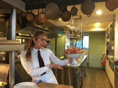 A server at Zuni Cafe dancing with lady apples.