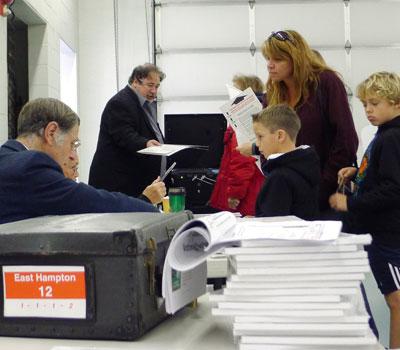 A voter, accompanied by two boys, checked in with Board of Elections poll-watchers at the Amagansett Fire House early Tuesday. A voter, accompanied by two boys, checked in with Board of Elections poll-watchers at the Amagansett Fire House early Tuesday.