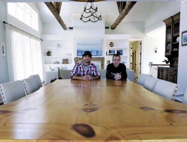 Jason Biondo, left, and Donnie Disbrow crafted this massive live-edge table in a Montauk client’s house from an old-growth eastern white pine using a technique called bookmatching, in which a thick slab is cut down the middle and fitted together so that both sides of the piece are almost mirror images of each other. They built a kitchen island in the house from the same tree.