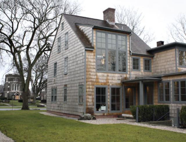 The house was extended to the rear, and the attic was removed to allow the second-floor master bedroom to soar behind double-height windows.