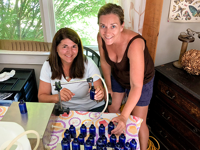 The dining table doubles as an assembly line for Lisa-Jae Eggert, left, and Jennifer Decker of 3 Moms Organics, who mix, fill, and label every bottle of their TickWise Protector repellent themselves.