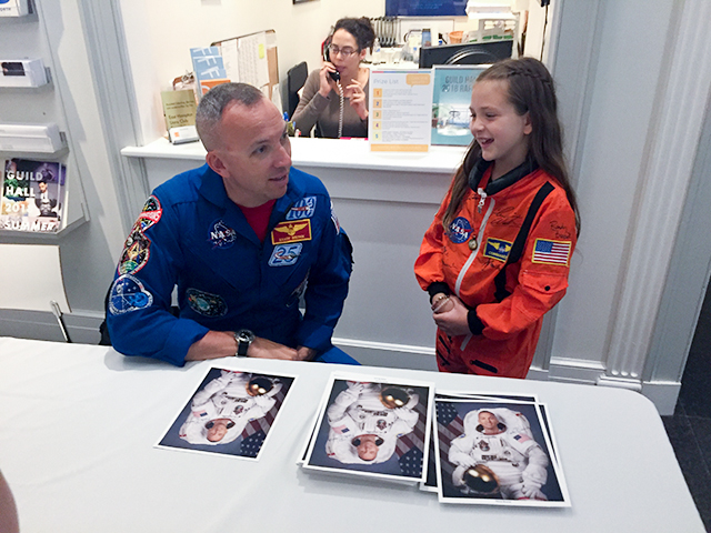 After first signing Brooke Stimpson’s space suit, Col. Randolph Bresnik, a NASA astronaut who had been commander of the International Space Station, autographed a photograph of himself at Guild Hall.	Iris Smyles Photos