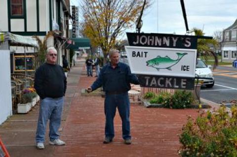 Johnny Kronuch, left, owner of Johnny’s Bait and Tackle, stood with Tom Brown, who has been caring for the store’s neon sign for many years. The business is closing and the sign will go to Mr. Kronuch’s son.