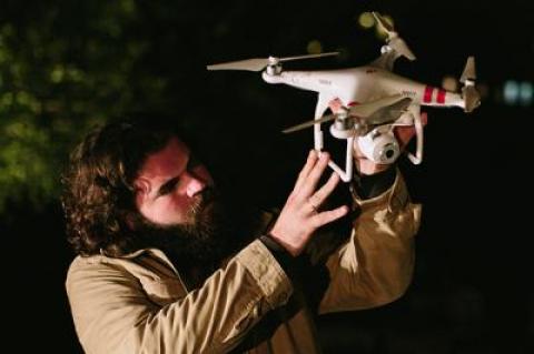 The Poet (Patrick Vincent Curran) inspects a drone in “An Iliad,” a one-person play that will be performed in the Reid Brothers junkyard in Sag Harbor next week.