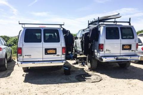 Surfing lesson operators have been criticized for taking too much space at Ditch Plain Beach in Montauk, like these vans used by the Corey's Wave company, and creating havoc in the water, as well as making aggressive sales pitches to passers-by.