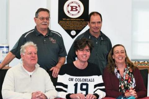 Ryan Fowkes, center, signed Monday a letter of intent to attend George Washington University in Washington, D.C. He was flanked by his father, Bill, and his mother, Jennifer, with Bill Herzog, his middle school coach, and Kevin Barry, his varsity cross-country coach, behind him.