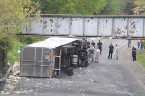 A tractor-trailer landed on its side after it struck the Long Island Rail Road overpass on Route 114, near Cove Hollow Road, on Tuesday morning. A tractor-trailer landed on its side after it struck the Long Island Rail Road overpass on Route 114, near Cove Hollow Road, on Tuesday morning.