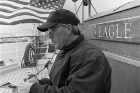 Russell Drumm writing aboard the U.S.C.G. Barque Eagle in 1996