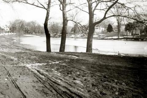 Main Street, East Hampton, in the days of horse and buggy, with the South End Burying Ground visible on the other side of a frozen Town Pond