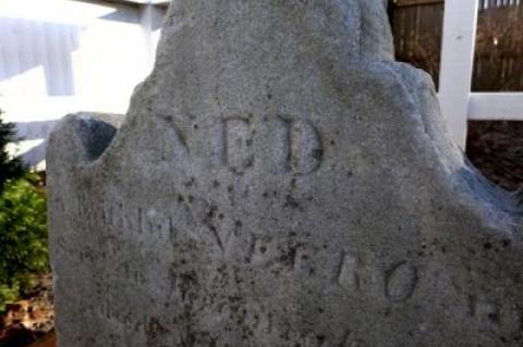 A marble gravestone marking the 1817 burial of Ned, described as a free black man in a contemporary deed, has been returned to its rightful place on a tiny, hidden plot in East Hampton.