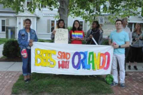 Tom House, right, is an English teacher at the Bridgehampton School who got a group of students involved in planning the vigil held Tuesday to remember the victims of the mass shooting in Orlando. The students are pictured here holding the banner they made earlier in the day on Tuesday.