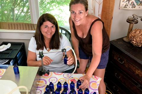 The dining table doubles as an assembly line for Lisa-Jae Eggert, left, and Jennifer Decker of 3 Moms Organics, who mix, fill, and label every bottle of their TickWise Protector repellent themselves.