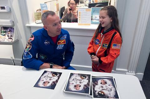 After first signing Brooke Stimpson’s space suit, Col. Randolph Bresnik, a NASA astronaut who had been commander of the International Space Station, autographed a photograph of himself at Guild Hall.	Iris Smyles Photos